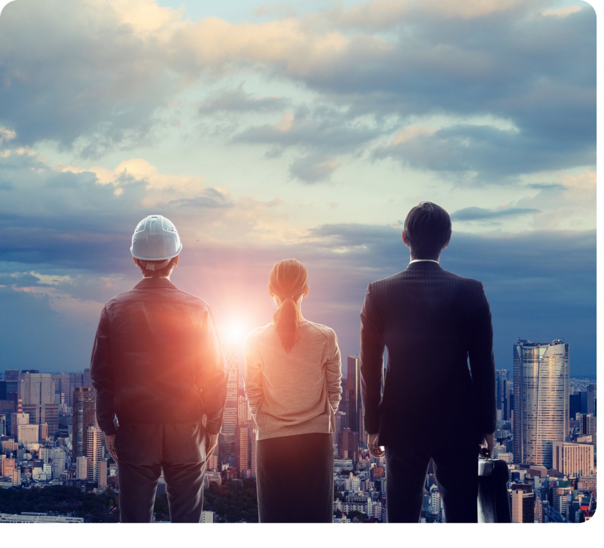 Business team overlooking city skyline at sunset.